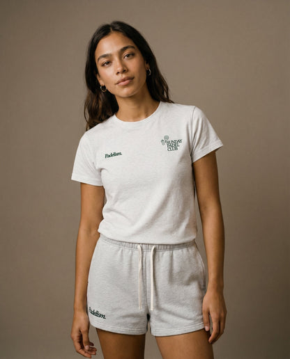 White crewneck short-sleeve t-shirt with small chest prints, paired with light gray shorts