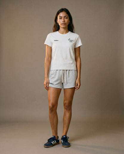 White crewneck short-sleeve t-shirt with chest prints, worn with light gray drawstring shorts