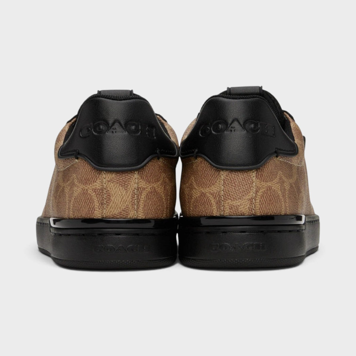 Back view of brown and black low-top trainers with black heel panels and rubber sole