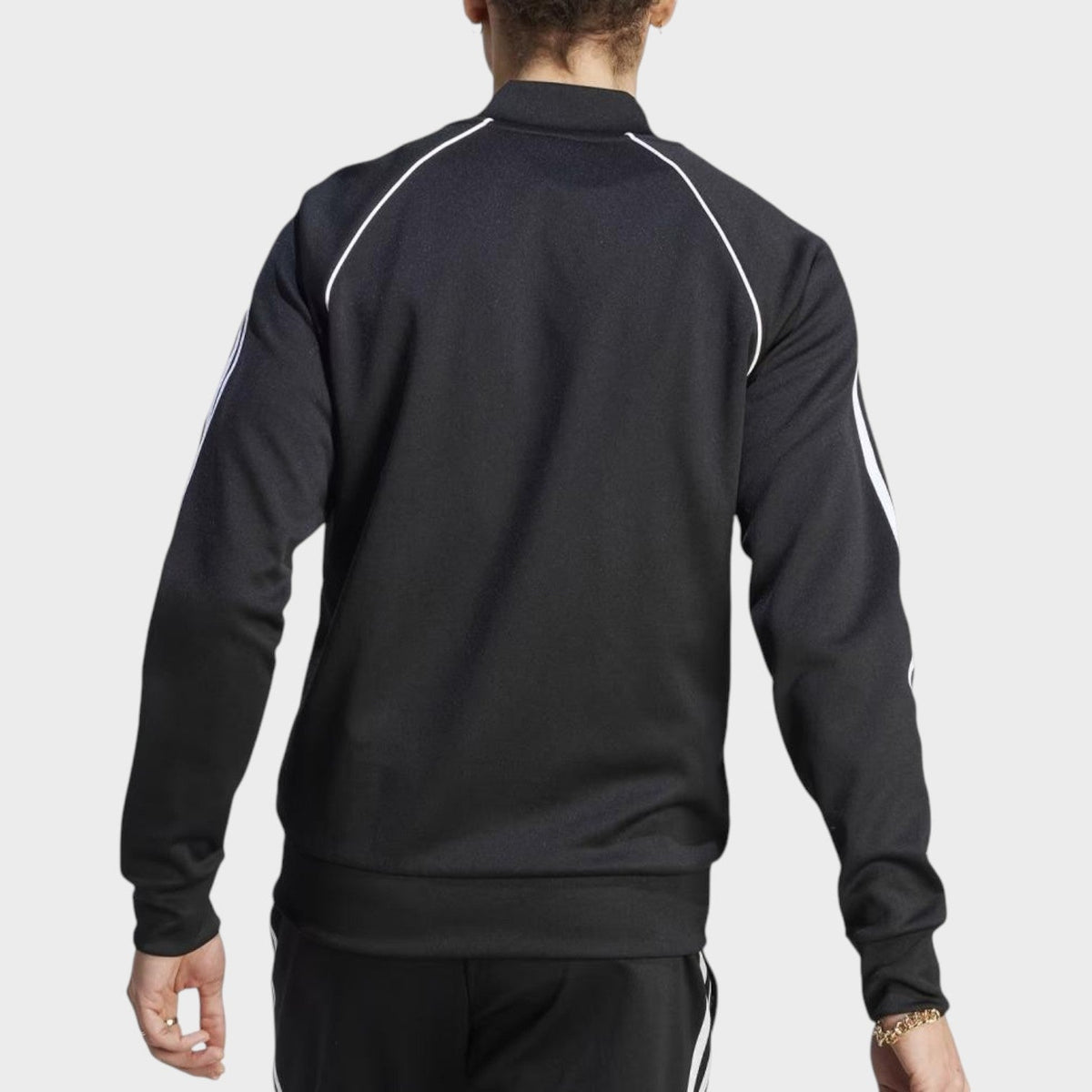 Black track jacket back view with white triple stripe sleeves and ribbed hem cuffs