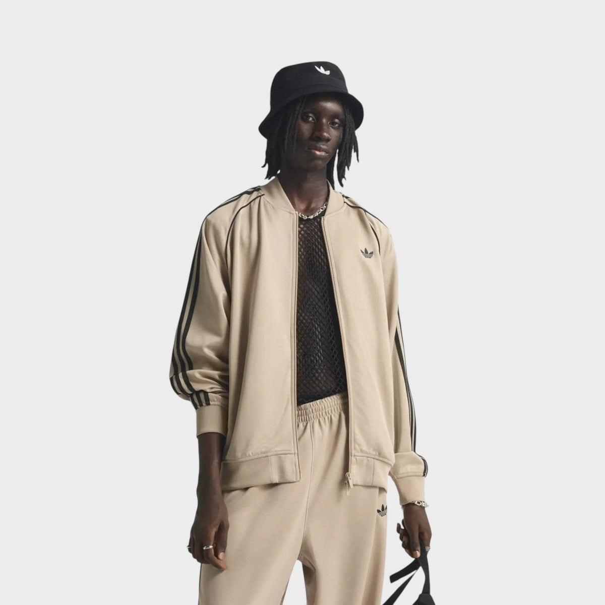 Beige adidas track jacket with stand collar, zipper front, and black sleeve stripes