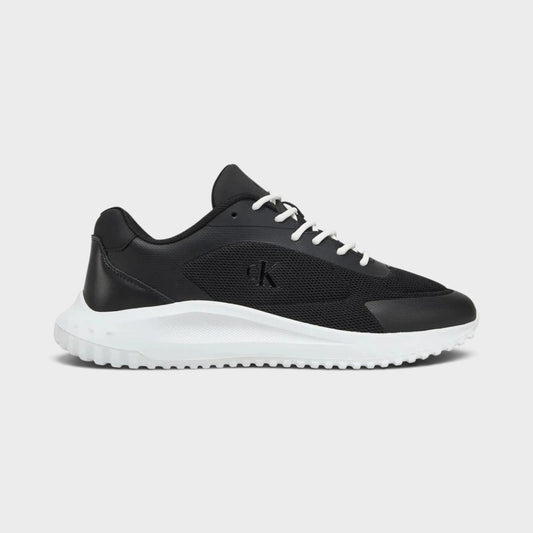 Black low-top mesh sneakers with white laces and chunky white rubber sole