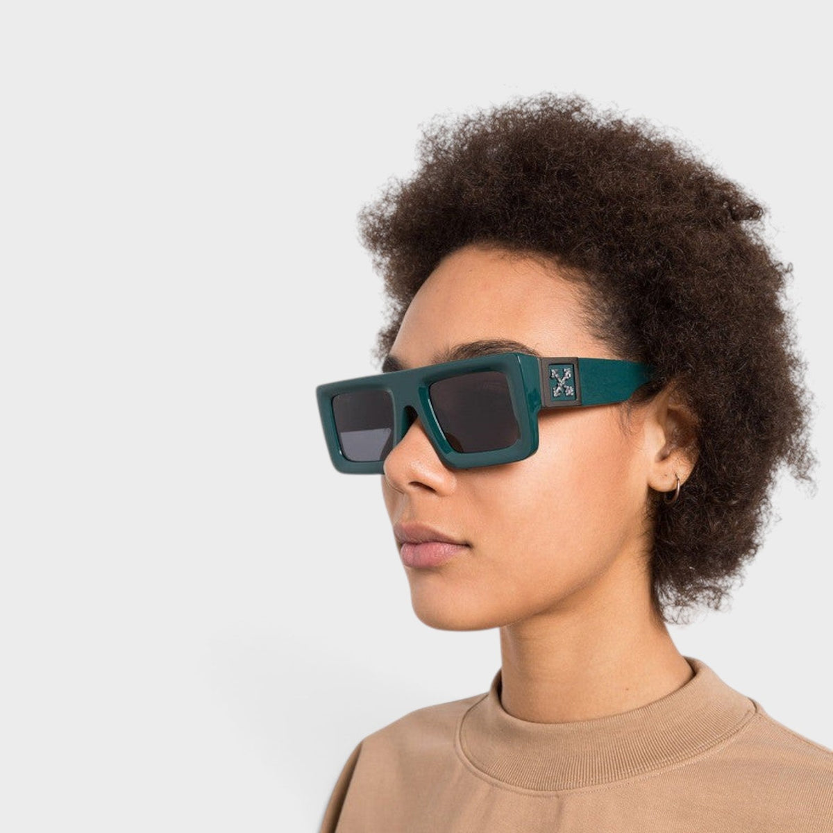 Green square sunglasses on model, dark tinted lenses and geometric front badge