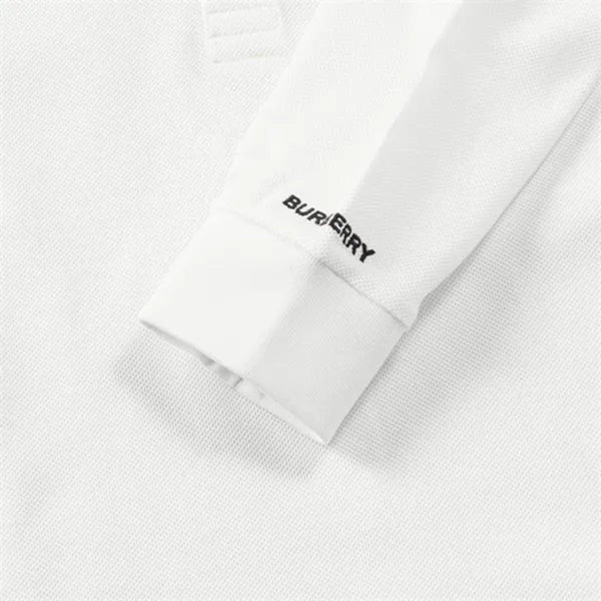 White polo sleeve cuff with Burberry logo embroidery and clean stitched hem.