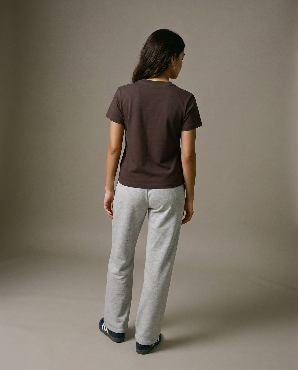 Brown crewneck t-shirt with short sleeves, worn with light gray sweatpants.