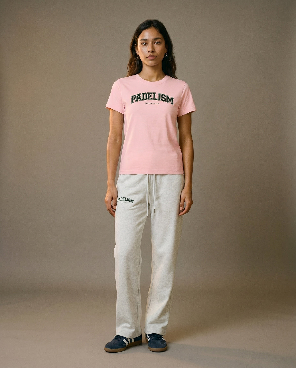Pink crewneck t-shirt front view with short sleeves, worn with light gray pants.