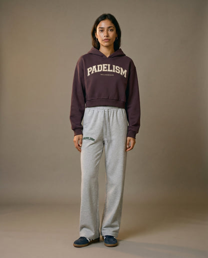 Cropped pullover hoodie in dark reddish purple with hood and front logo, long sleeves