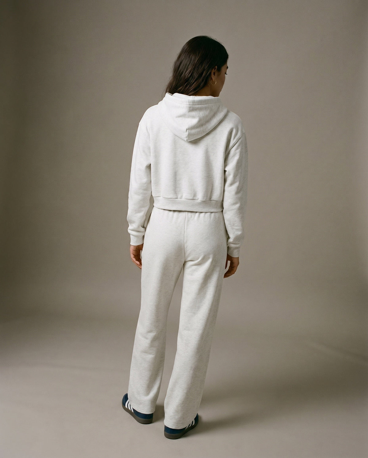 Cropped pullover hoodie in light gray with hood and long sleeves, back view