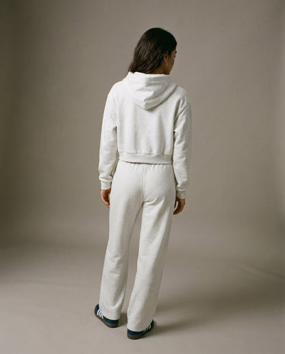 Cropped pullover hoodie in light gray with hood and long sleeves, back view