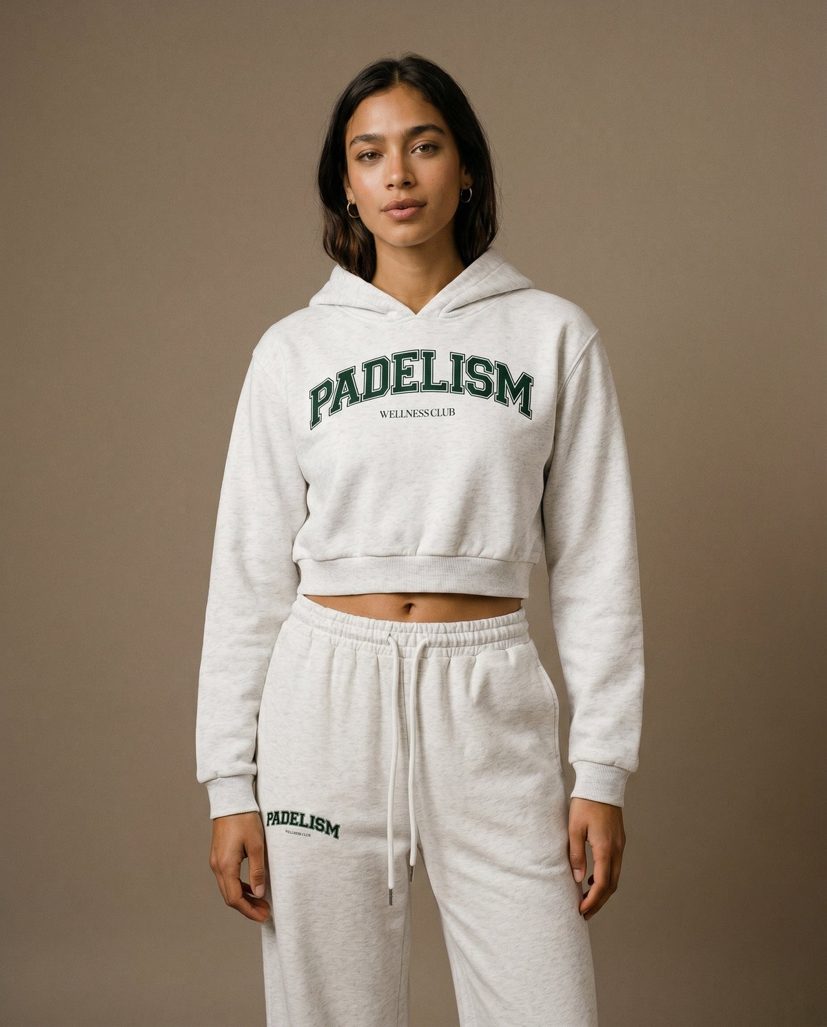 Cropped pullover hoodie in light gray with green logo text on chest and hood