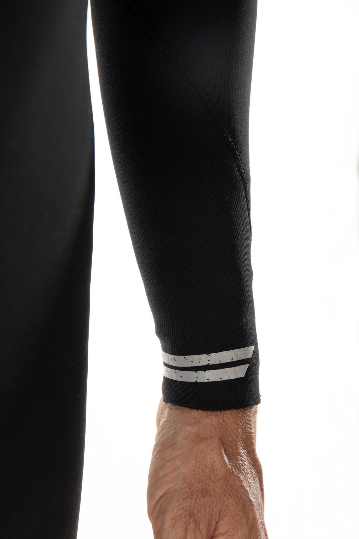 Black wetsuit leg with white stripe at ankle and smooth fabric panels